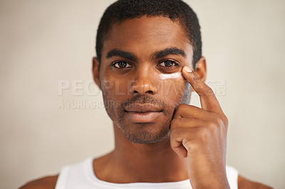 Buy stock photo A young man applying face cream