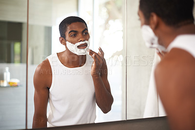 Buy stock photo Black man, mirror and shaving cream on face in bathroom for grooming, skincare or morning routine. Reflection, beard and person apply foam for cleaning, health and hair removal for hygiene in home