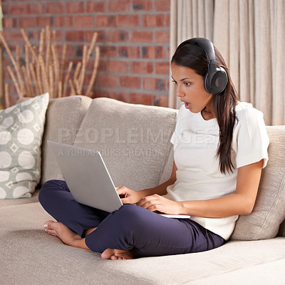 Buy stock photo Shocked, home and woman with headphones, laptop and internet connection on sofa listening to music. Female person relax on couch to listen to wow, surprise or fake news announcement online with tech