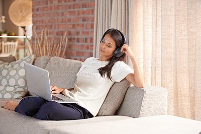 Buy stock photo Headphones, laptop and home with woman listening to music, streaming movies and tech. Female person relax on sofa at computer for online radio, elearning blog and remote work with internet connection