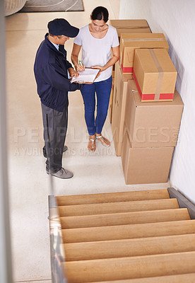 Buy stock photo A young woman receiving a package from a delivery man