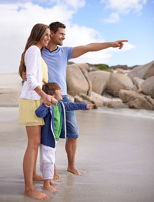 Buy stock photo Family, child and pointing outdoor at beach for travel, adventure or holiday in summer with a smile. A man, woman and kid or son together on vacation at sea for blue sky, learning and happiness