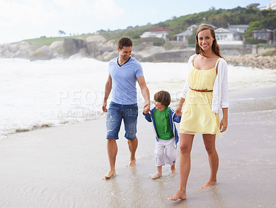 Buy stock photo Family, portrait and holding hands while walking at beach for travel, fun or holiday in summer with a smile. Man, woman and child or son walk together on vacation at sea with happiness, love and care