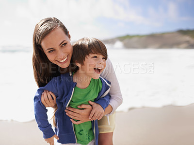 Buy stock photo Shot of a young mother playing with her son at the beach