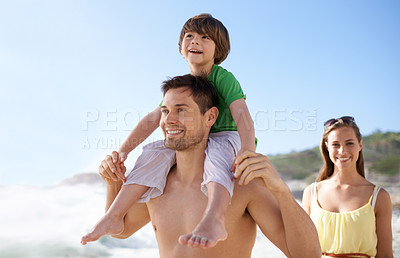 Buy stock photo Family, child and walking outdoor on beach for travel, fun or holiday in summer with a smile. Man, woman and child on shoulders for vacation, adventure or walk at sea with happiness, love and care