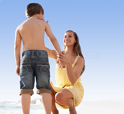 Buy stock photo Mother, child or family at beach with sunscreen lotion on body for sun protection on travel or holiday in summer. A woman and kid or son together on vacation at sea with blue sky, cream and happiness