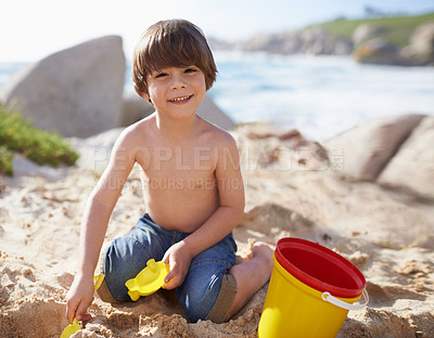 Buy stock photo Sand castle, beach and portrait of child with bucket and toys on summer holiday, vacation and relax by ocean. Childhood, building sandcastle and young boy playing for adventure, fun or weekend by sea