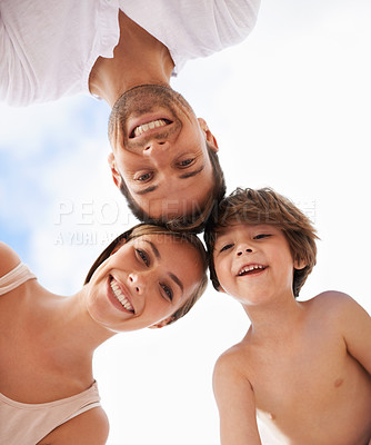 Buy stock photo Low angle view of a happy family standing with their heads together