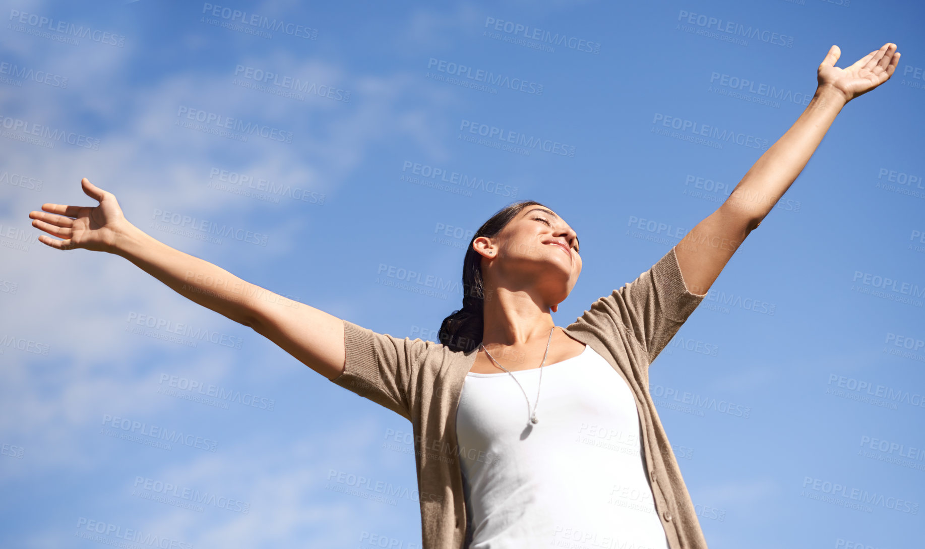 Buy stock photo Smile, freedom and blue sky in summer with woman hands raised outdoor in fresh air of nature. Environment, happy or relax and young person satisfied with travel, vacation or holiday from below