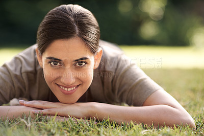 Buy stock photo Portrait, Indian woman and lying on grass with smile at park for joy, refresh and relax with me time. Female person, bokeh and happy for leisure with break for rest, peace and quiet with wellbeing