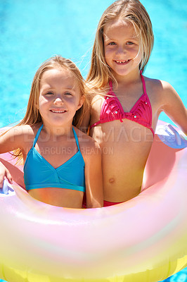 Buy stock photo Girls, summer and pool with inflatable tube on vacation, swimwear and fun in sunlight for holiday. Happy, kids ad entertainment with smile and toy, children in water for swimming together outdoors