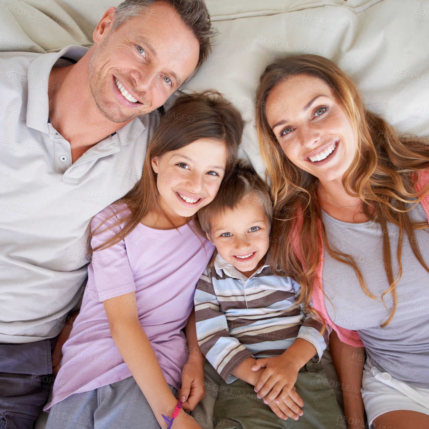 Buy stock photo Love, portrait and happy family in bed for relax on holiday, vacation or hotel accommodation on weekend. Face, parents and children with smile, bonding and above in bedroom with healthy relationship