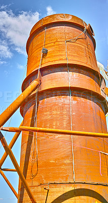 Buy stock photo A tall silo water tower against a blue sky background from below. An orange storage tank for the farming or agriculture industry used for large scale grain or wheat production on a farm 