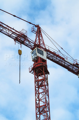 Buy stock photo Crane, construction and blue sky background for building with heavy metal, steel or machinery outdoor. Hoist in city, urban or industrial development in a low angle of overhead equipment and tools