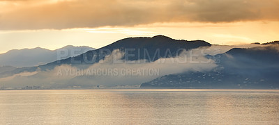 Buy stock photo Sea, sunset and fog in clouds with mountains, water and winter season in evening. New Zealand, travel and destination for holiday in island, landscape and environment for vacation with scenery