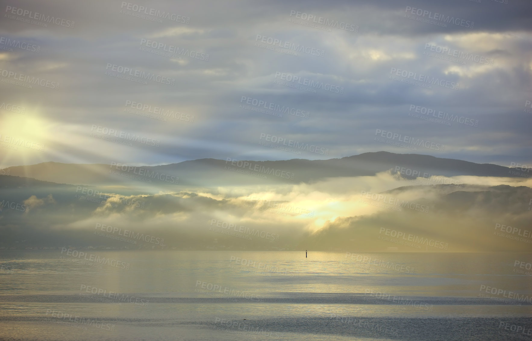 Buy stock photo Sea, sunset and cloud on mountains in morning, reflection and island with landscape in nature. Blue sky, clouds or sunlight on water on beach, calm or sunrays on sustainable environment or seascape