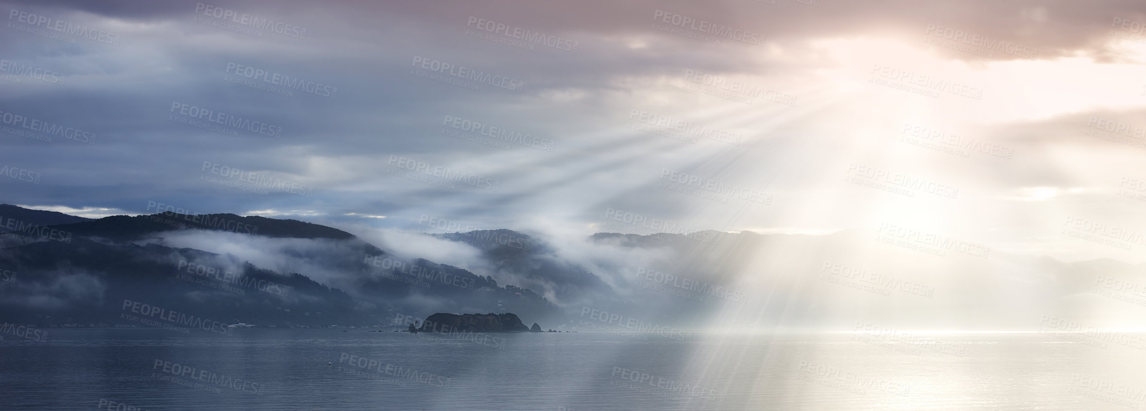 Buy stock photo Sun rays, sea and clouds in blue sky with mountains, water and fog in evening. Lake, landscape and environment for holiday in summer, travel and destination for vacation or peace with scenery