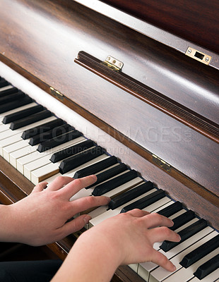 Buy stock photo Hands learning to play piano at home in a calm atmosphere. Person composing relaxing classical music using a musical keyboard. A pianist improving and practicing to master the classic instrument. 