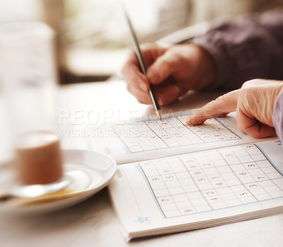 Buy stock photo Woman trying to solve Sudoku Puzzle - window, sunlight, and coffee