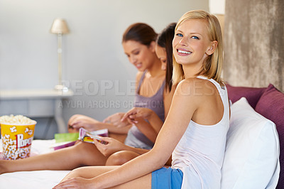 Buy stock photo Portrait, woman and smile on bed in home with friends, magazine and bonding with popcorn at sleepover. Person, relax and face with happiness for support, pride and spending time together in house
