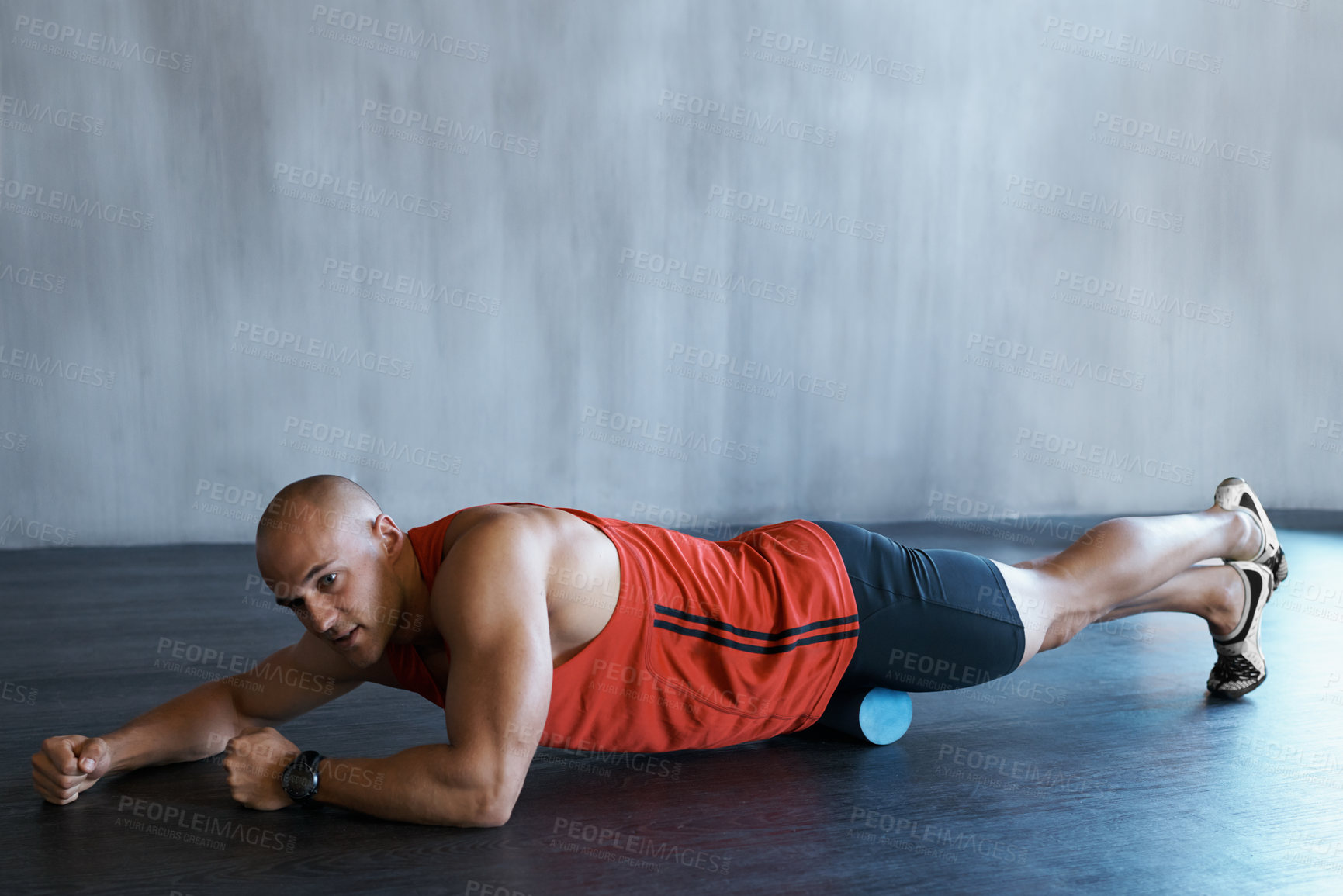 Buy stock photo A young man doing a workout with a foam roller