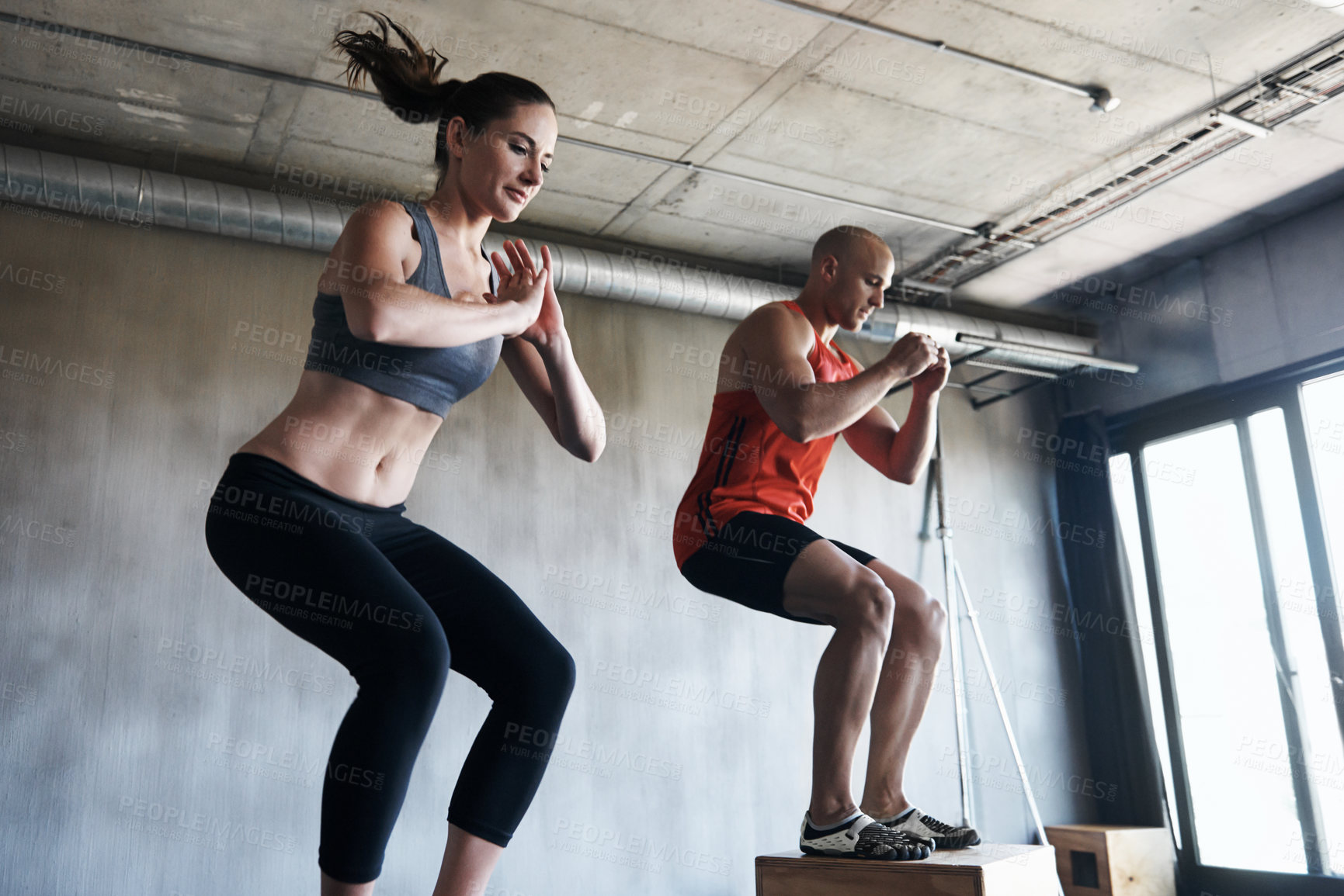 Buy stock photo Shot of a man and woman training together at the gym