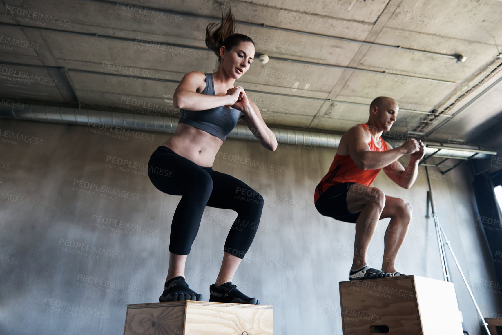 Buy stock photo Shot of a man and woman training together at the gym