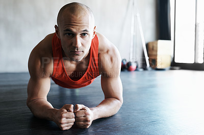 Buy stock photo Shot of a man doing plank exercises at the gym