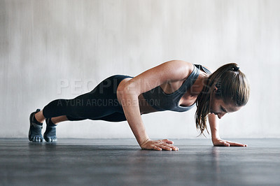 Buy stock photo Shot of a woman doing pushups at the gym