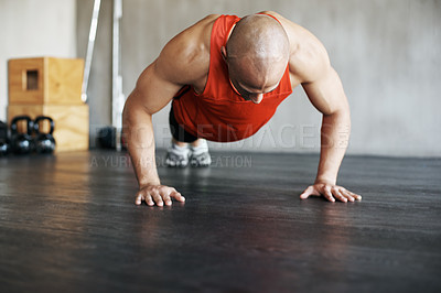 Buy stock photo Shot of a man doing pushups at the gym