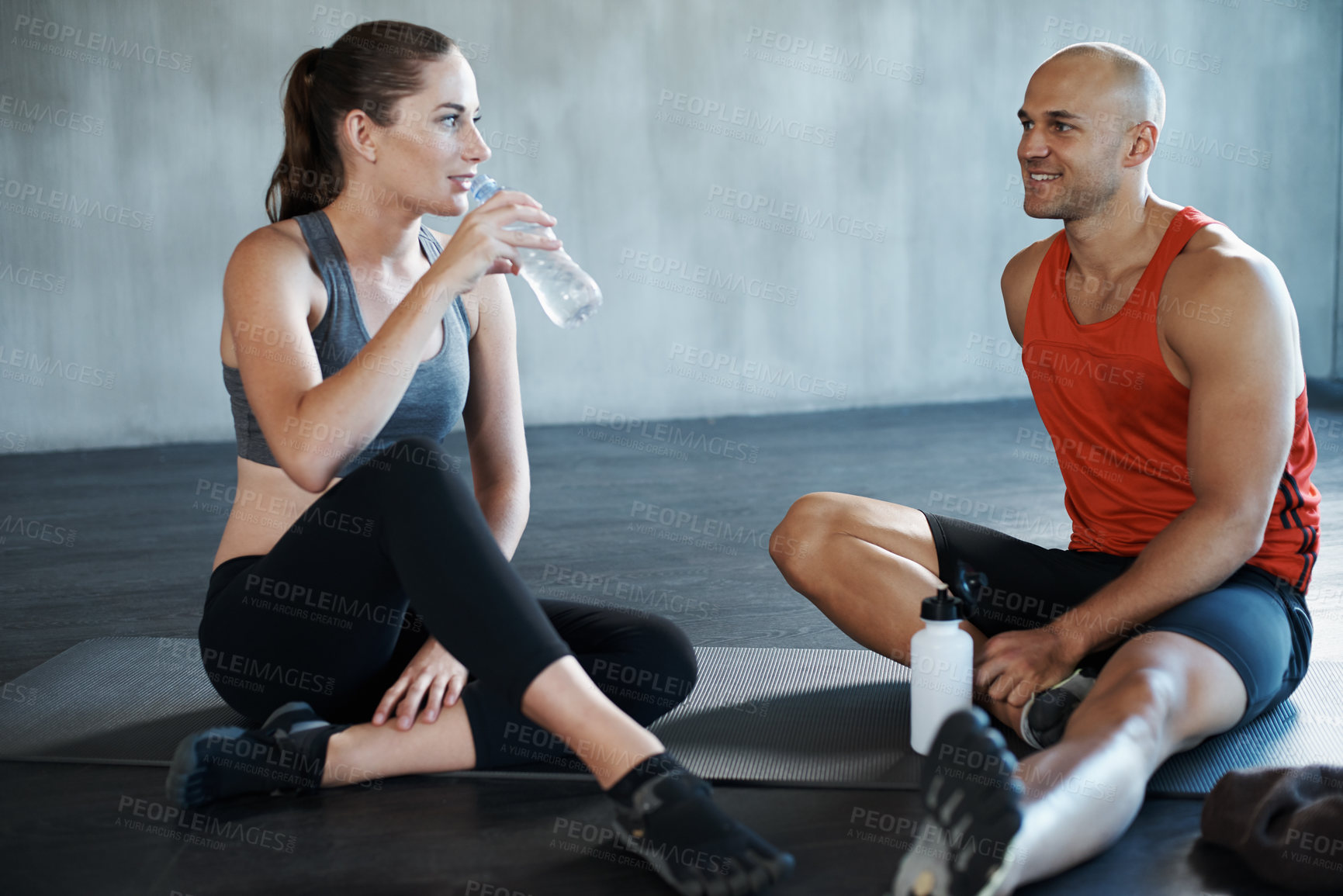 Buy stock photo Friend, fitness and relax on a gym floor for water, break and talking after cardio or routine. Active, people or woman with personal trainer relaxing after training, workout or physical exercise rest