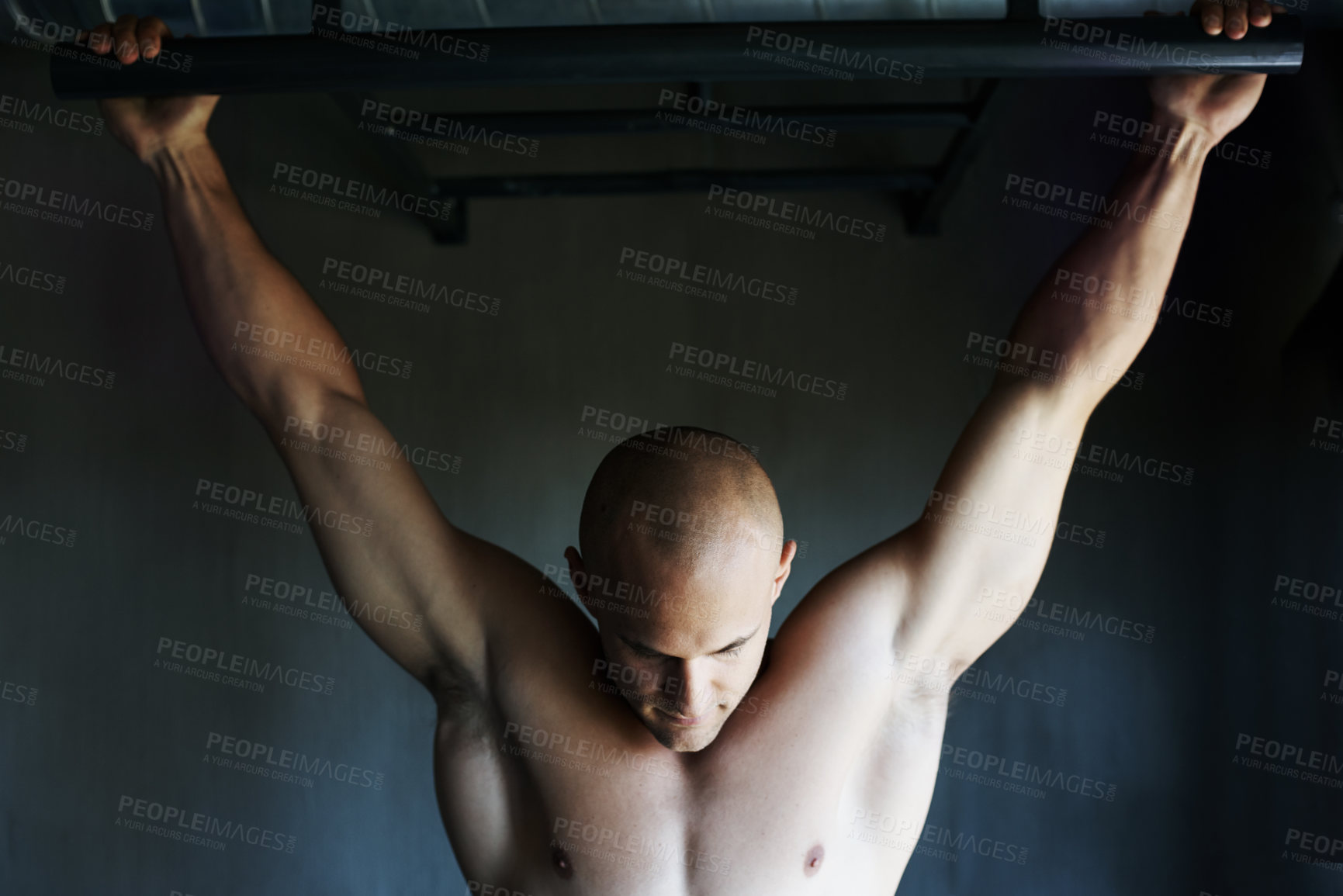 Buy stock photo Shot of a man doing pull-ups at the gym