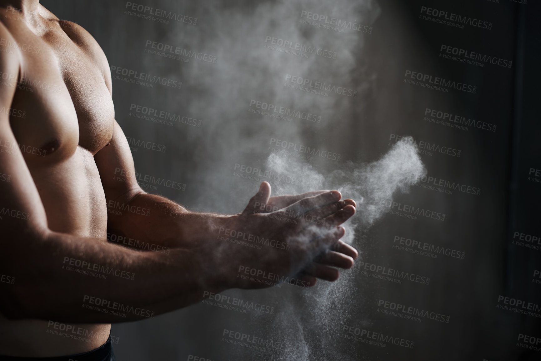 Buy stock photo A cropped view of a male gymnast dusting his hands with chalk
