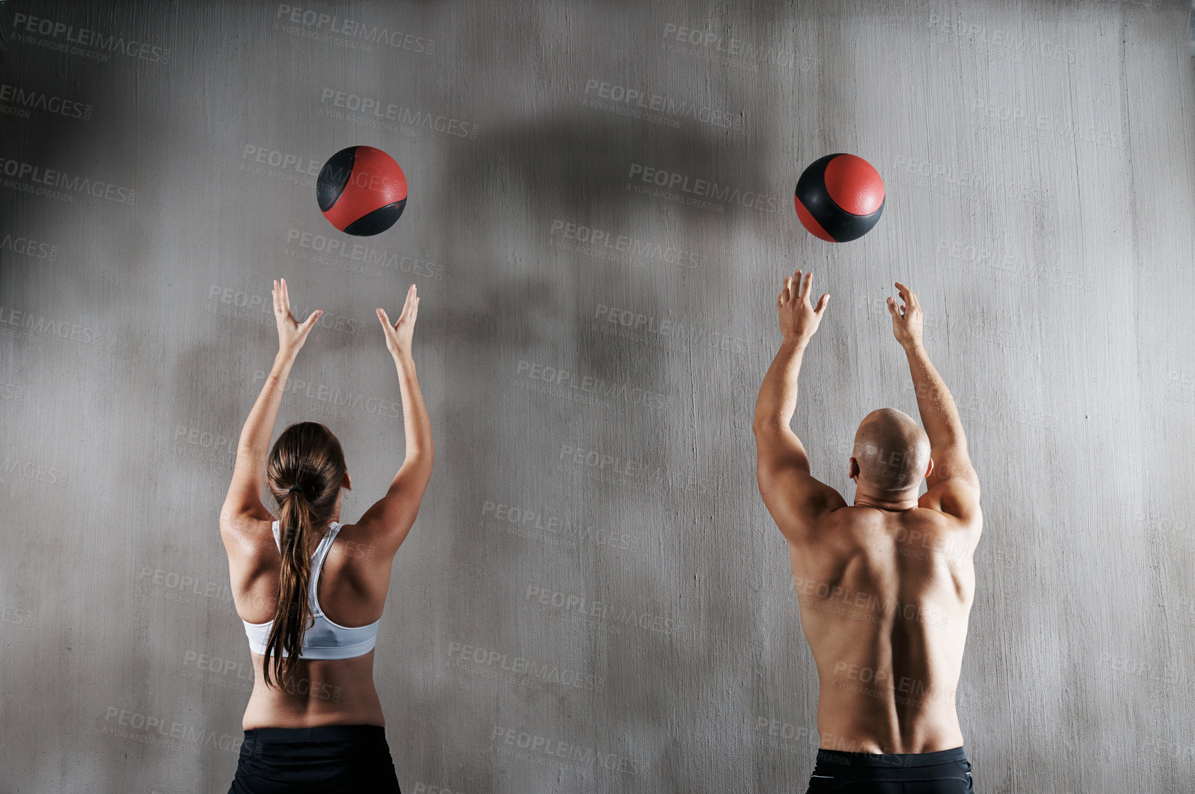 Buy stock photo Shot of a young man and woman working out with medicine balls at the gym