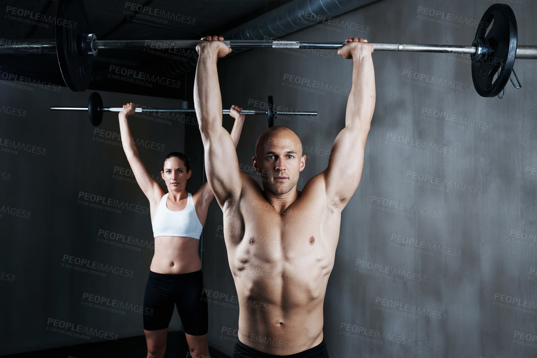 Buy stock photo Cropped shot of a man and woman working out with barbells