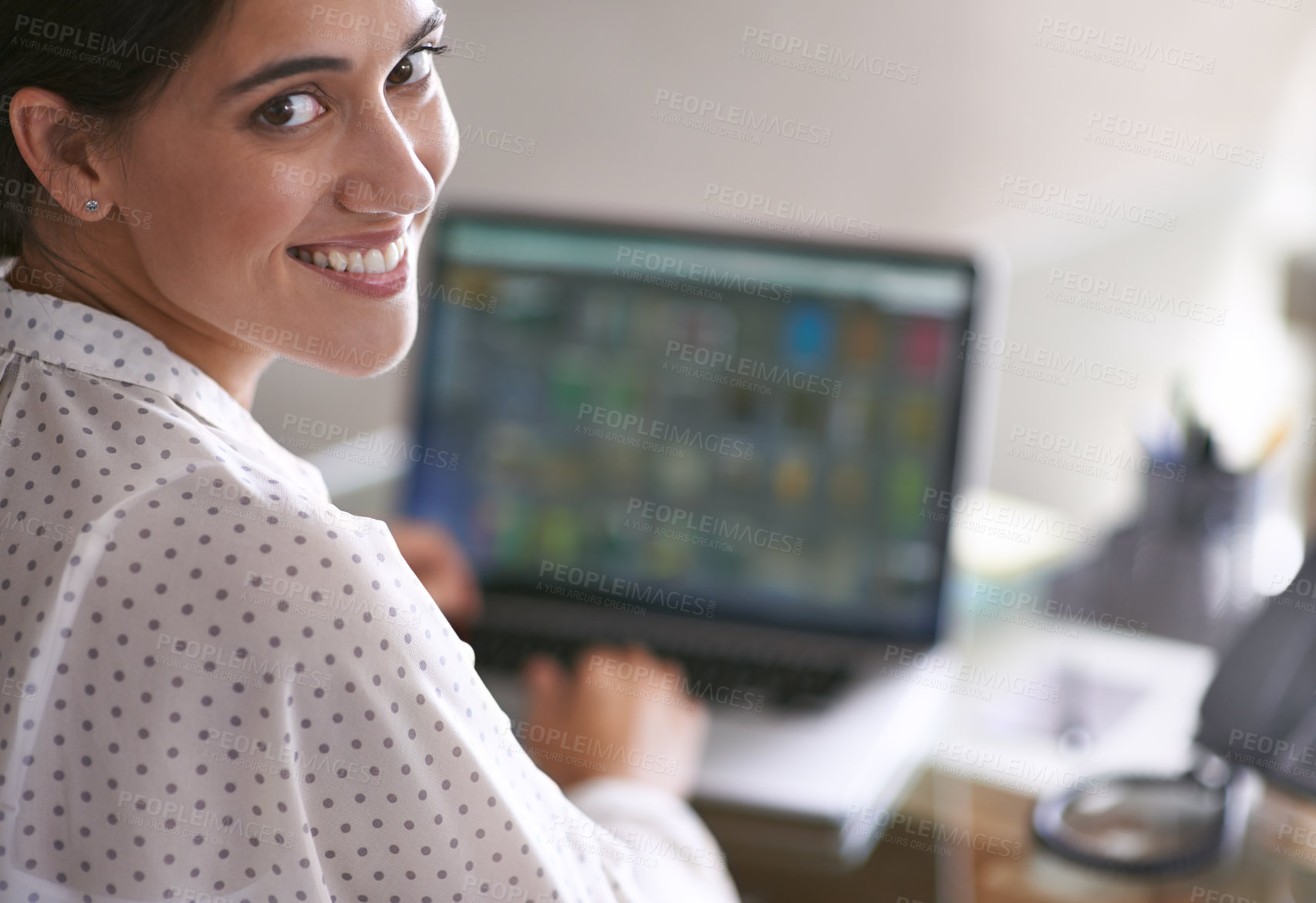 Buy stock photo A young woman happily working at her computer