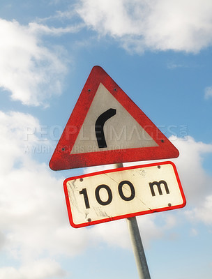 Buy stock photo A road sign indicating a bend in the road with copy space .A metal road symbol to indicate a sharp turn ahead. Big curve warning for travellers or drivers against blue cloudy copyspace background 