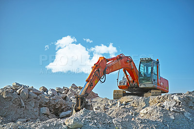 Buy stock photo Bulldozer in action at construction site. An industrial excavator on an open road section loading heavy concrete, rocks and dirt. Motorized machine equipped for pushing material, soil, sand or rubble