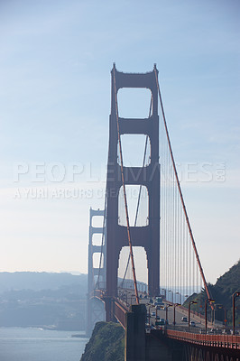 Buy stock photo A large suspension bridge across the water on a sunny afternoon 