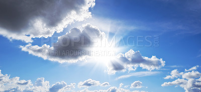 Buy stock photo Sunbeams shining through dark clouds in the sky