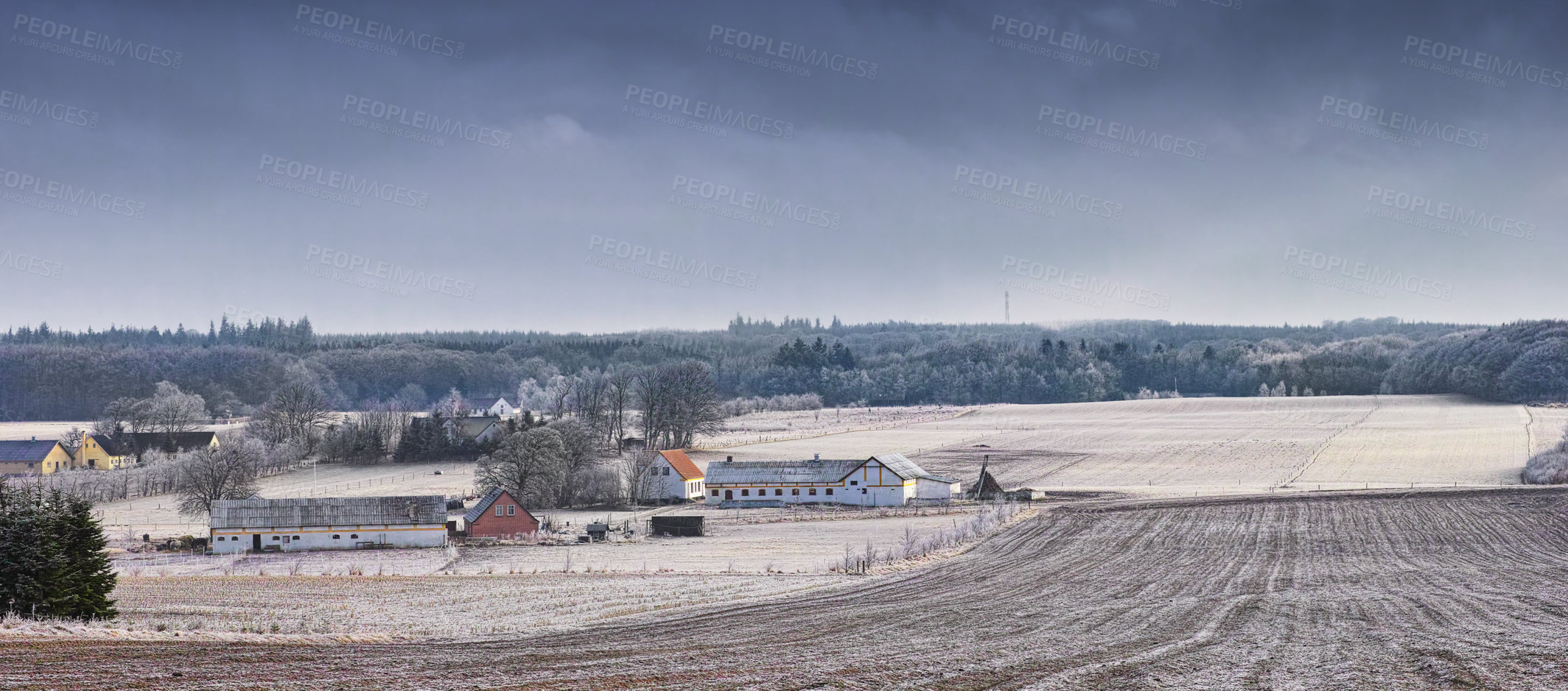 Buy stock photo A piece of cultivated land covered in frost next to farm buildings in the Danish countryside