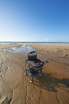 Buy stock photo Stroller, sand and blue sky by beach in nature for travel, vacation or holiday in summer. Baby pram, coast and ocean by seashore for tropical weekend trip on outdoor island destination in Cape town.