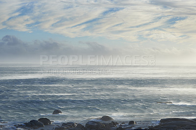 Buy stock photo Clouds, sky and sea with rocks in nature for vacation, holiday or weekend trip in summer. Stones, water and ocean waves by tropical island for travel in Cape town for outdoor paradise scenery.
