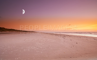 Buy stock photo The moon rising over a desolated beach as the sun sets over the ocean