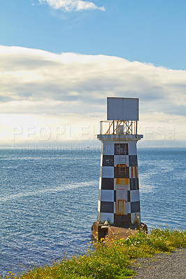 Buy stock photo Lighthouse, ocean and blue sky by beach in nature for holiday, vacation or travel destination. Water, clouds and signal tower by sea for outdoor summer weekend trip on tropical island in cape town.