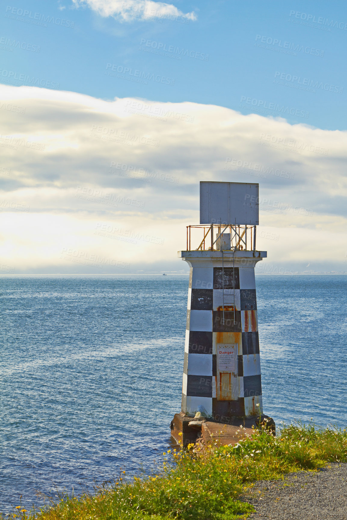 Buy stock photo Lighthouse, ocean and blue sky by beach in nature for holiday, vacation or travel destination. Water, clouds and signal tower by sea for outdoor summer weekend trip on tropical island in cape town.