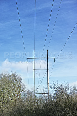 Buy stock photo Power lines against clear blue sky background with copyspace. Industrial energy line, shut down for power cuts, roller power cuts. Controlling the energy crisis or preventing a total blackout