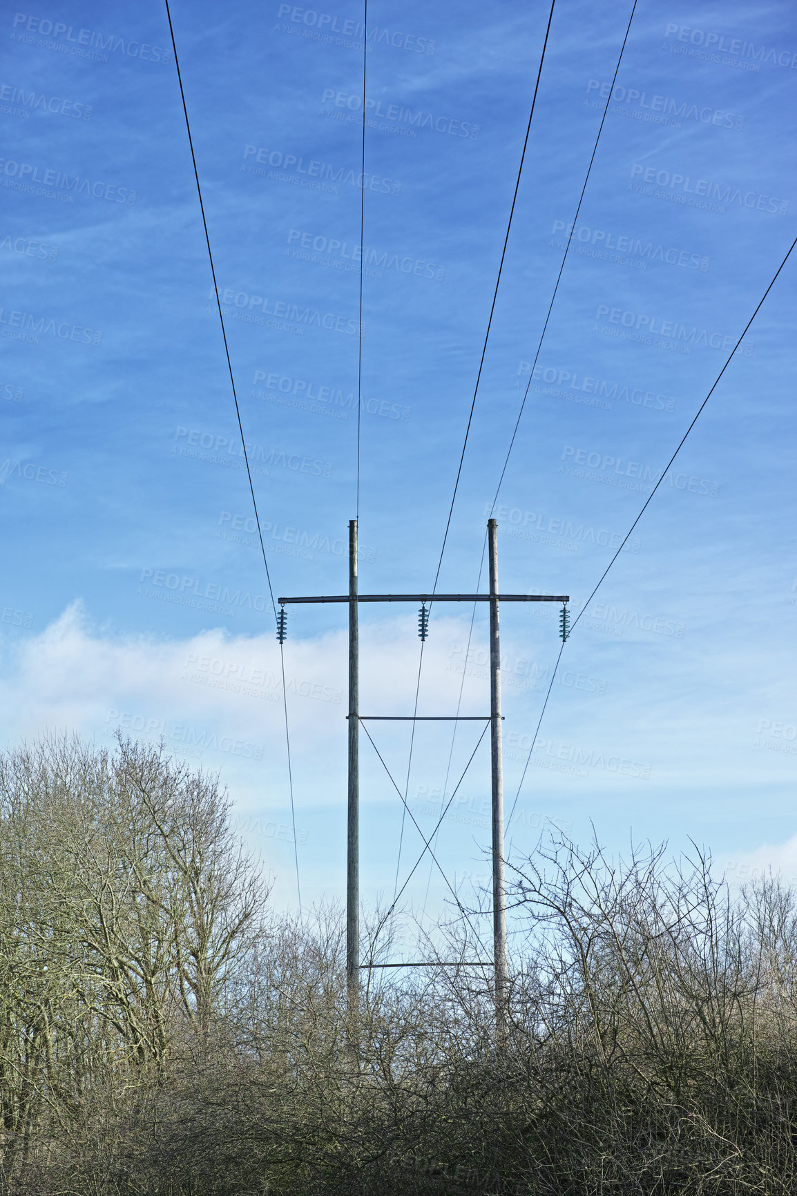 Buy stock photo Power lines against clear blue sky background with copyspace. Industrial energy line, shut down for power cuts, roller power cuts. Controlling the energy crisis or preventing a total blackout