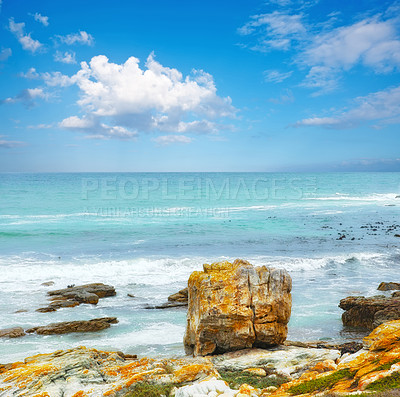 Buy stock photo A calm ocean on a sunny day seen from a rocky coastline