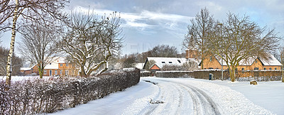 Buy stock photo Road, snow and houses with trees in countryside for travel, adventure and ocean with winter in nature. Street, pathway and location in Denmark with direction, roadway or neighbourhood in environment 